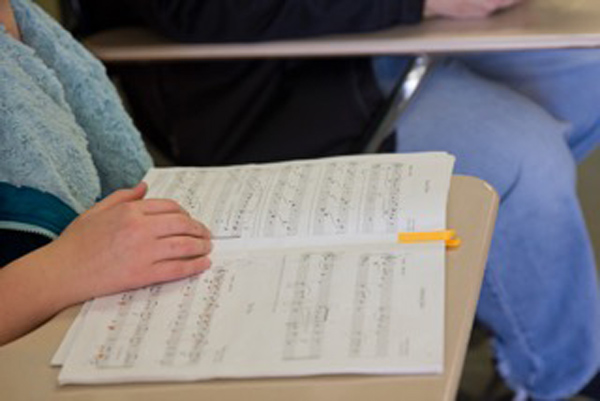 close up of sheet music on a desk infront of a student