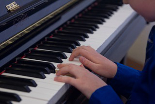 close up of students hands on a piano