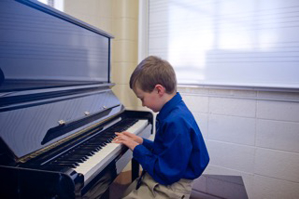 student looking at piano while playing it